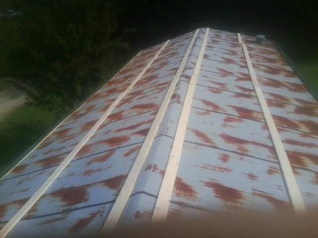 Rusted metal roof panels with new wood purlins before replacement — Storm Damage Roof Repair in Spragueville by Roofing Brothers