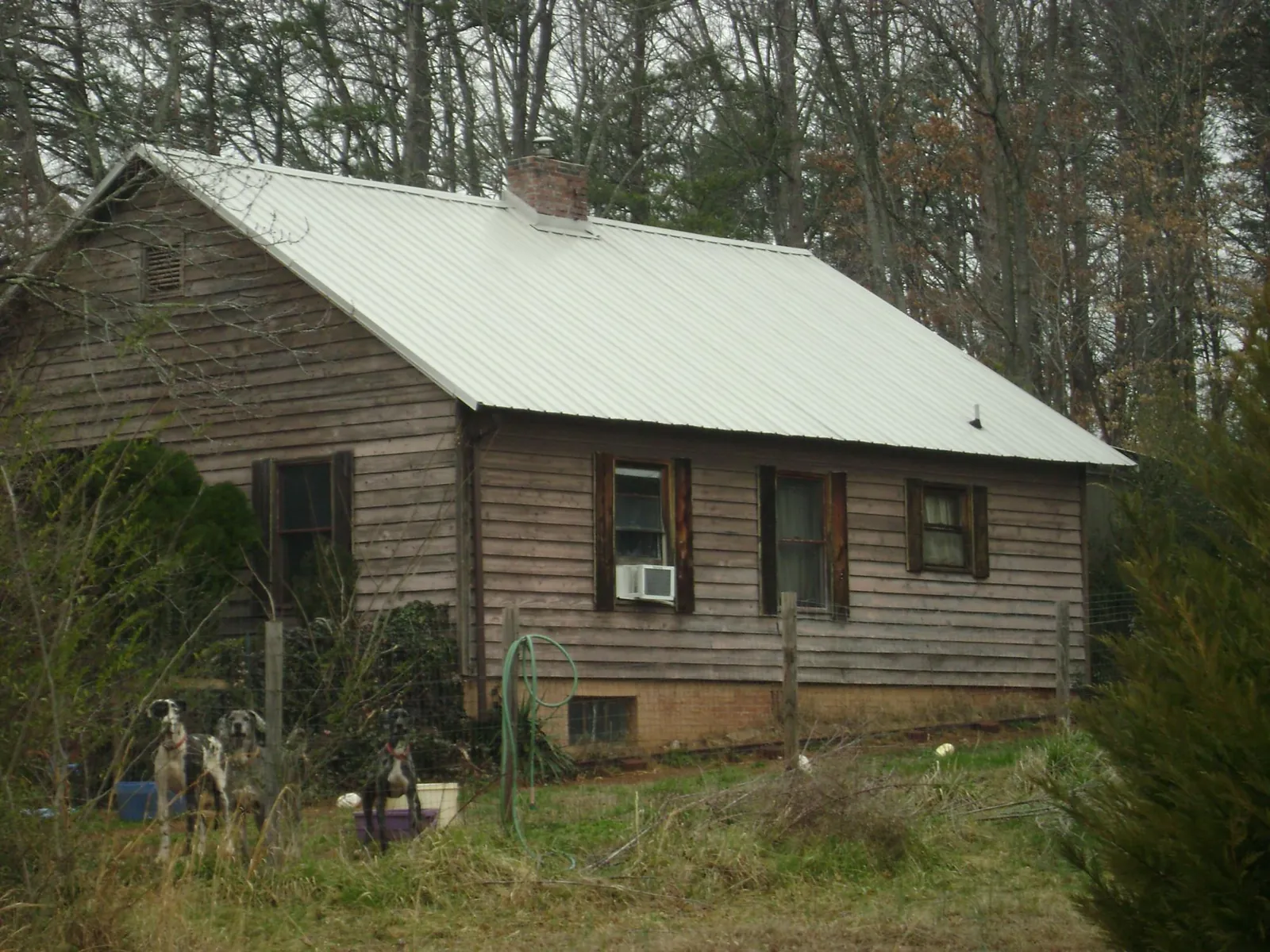 White metal roof on an old wood sided farmhouse, from a Metal Roof Installation job in Spragueville